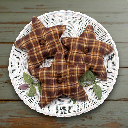 Set of three fabric homespun stars in brown, gold and tan with rusty bells in the centers