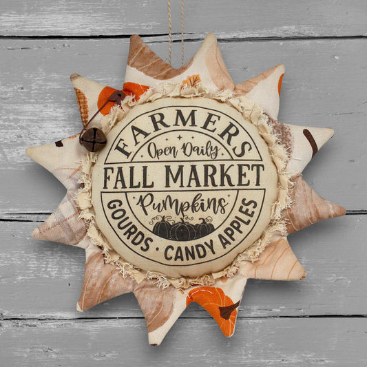 Primitive handmade fabric sunflower ornament with a printed center that advertises for a local fall farmers market