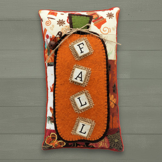 Autumn pillow tuck with a pumpkin and wooden tile letters reading 'F-A-L-L'