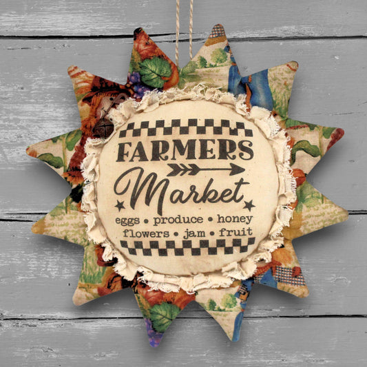 Primitive handmade fabric sunflower with a printed center that advertises for a farmers market