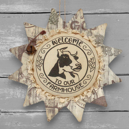 Primitive handmade fabric sunflower ornament or bowl filler with a printed center with an image of a cow and text that reads "welcome to our farmhouse."
