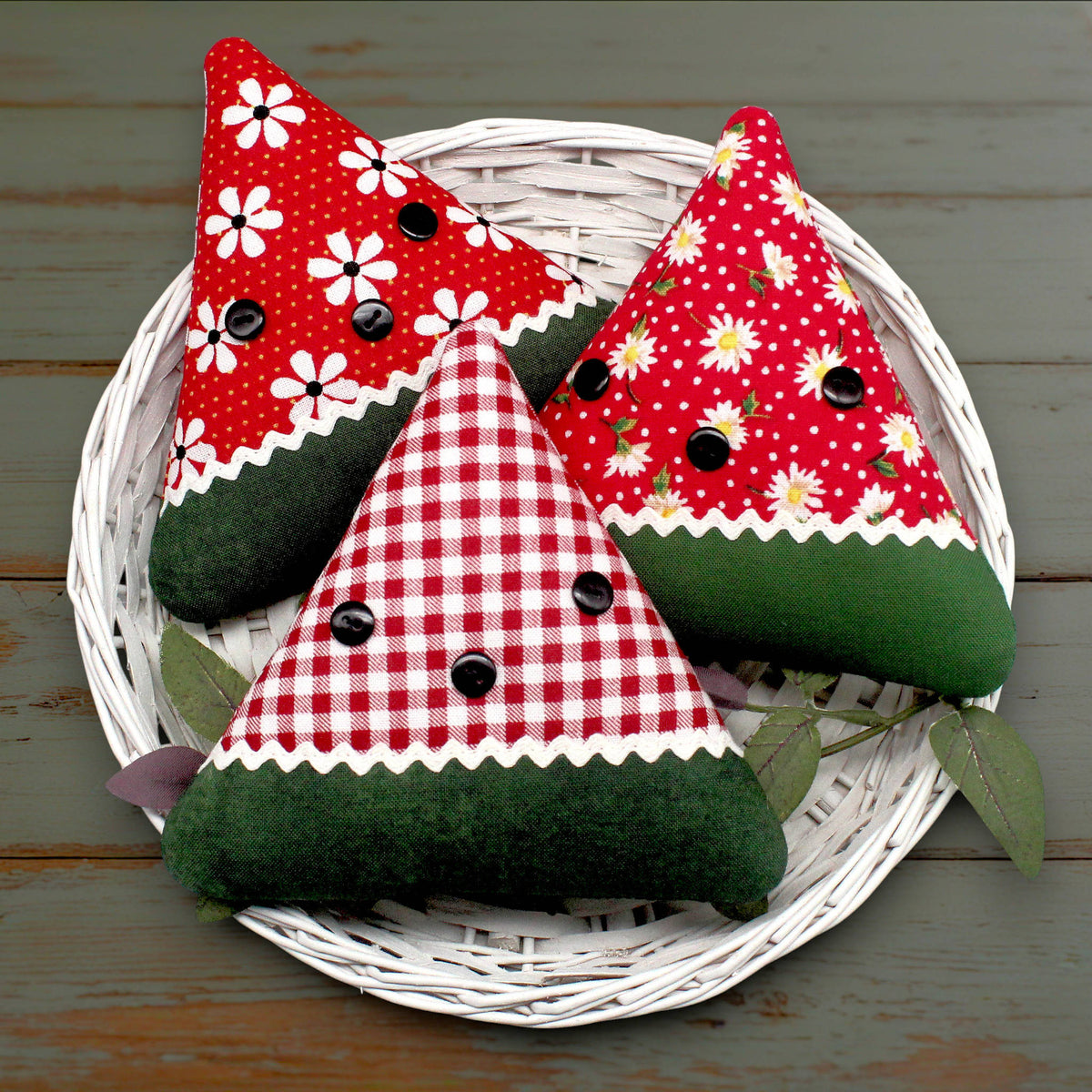 Set of three fabric watermelon slice bowl fillers sewn from coordinating red cotton prints, trimmed with white rick rack and black buttons