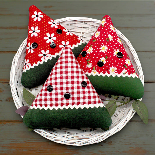 Set of three fabric watermelon slice bowl fillers sewn from coordinating red cotton prints, trimmed with white rick rack and black buttons