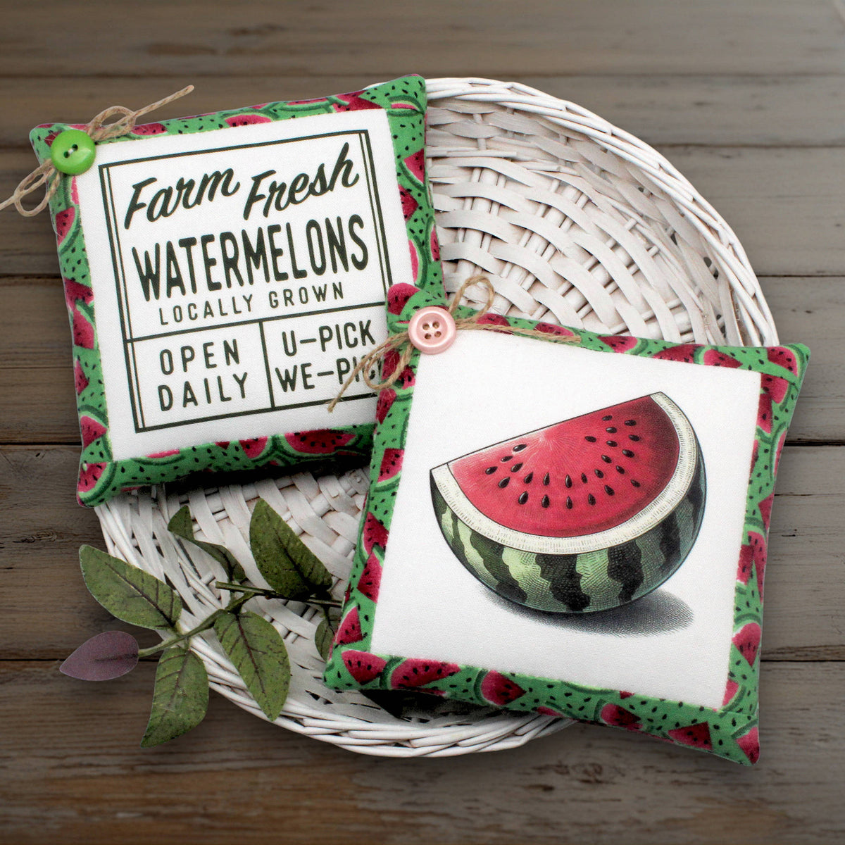 Set of two primitive mini pillow bowl fillers with watermelon designs, displayed on a white basket against a wooden background