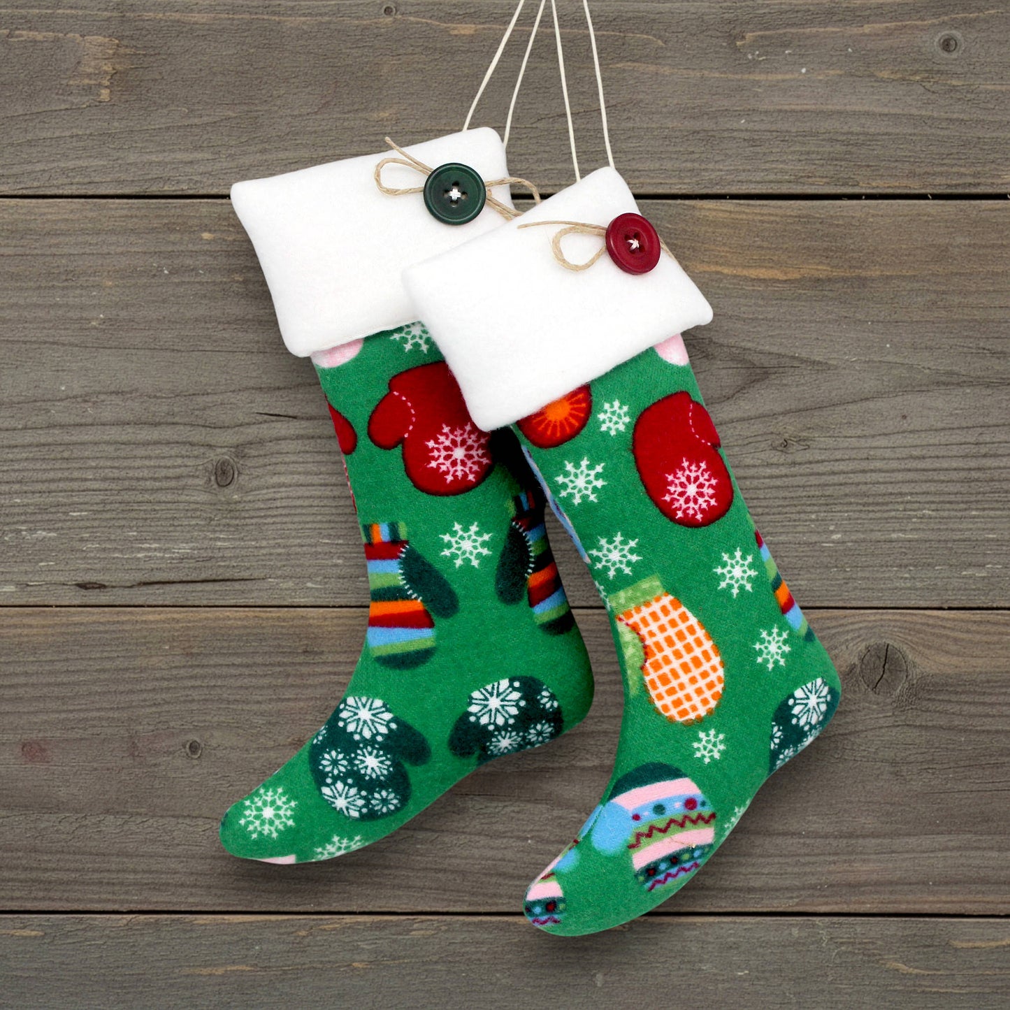Green Christmas stockings with festive patterns on a wooden surface