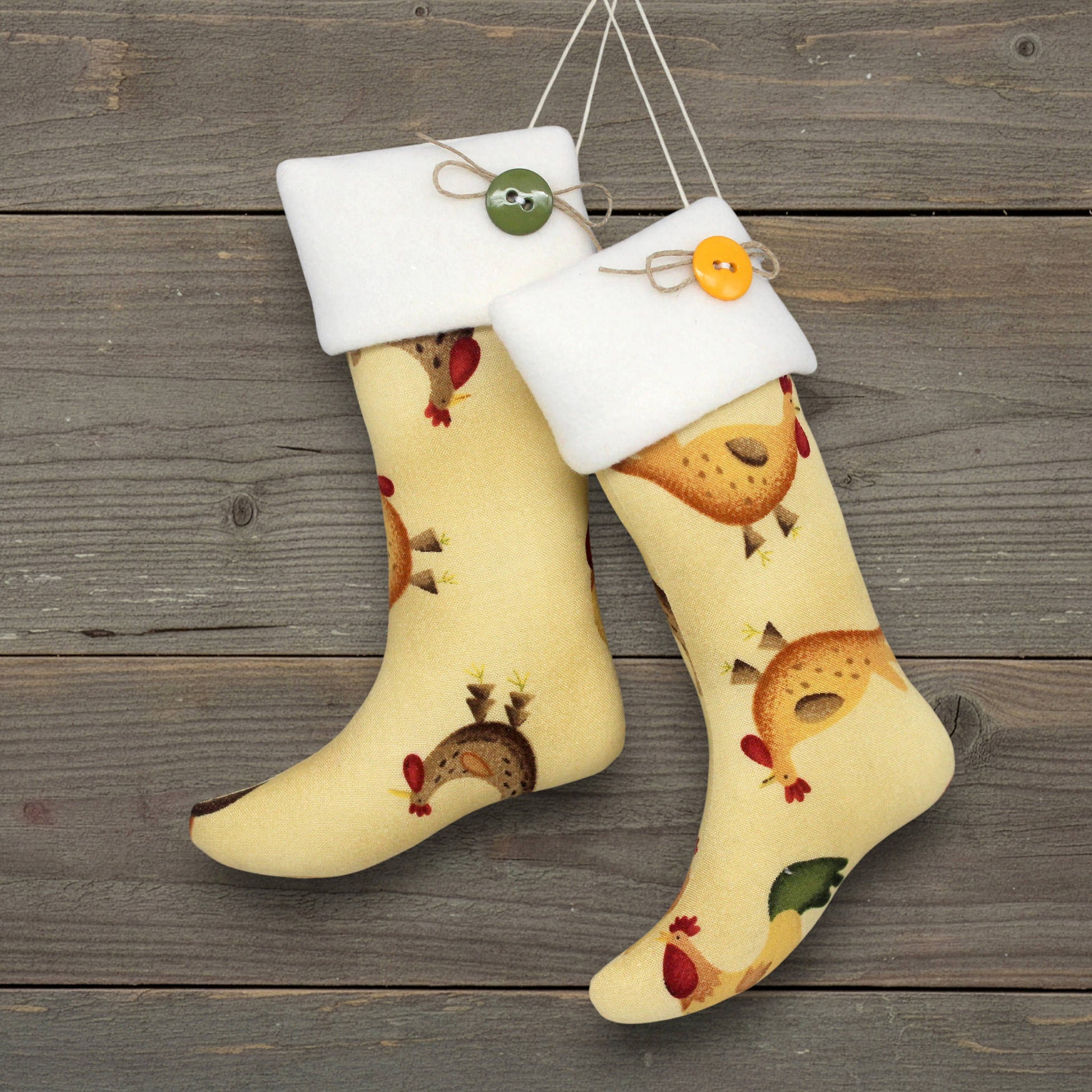 Pair of country farmhouse style Christmas stocking ornaments with chickens on a yellow background