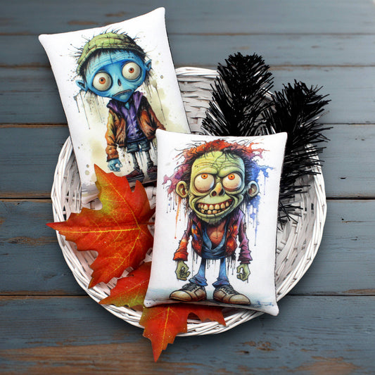 Two decorative pillows with cartoonish character funny zombies designs on a wooden surface with autumn leaves.