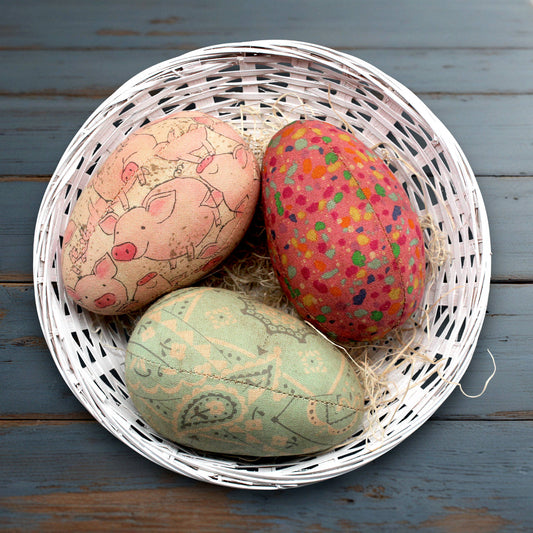 Decorative eggs with animal prints in a white basket on a wooden surface