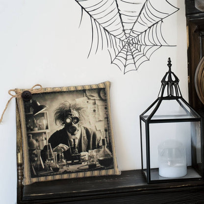 Decorative pillow with a creepy mad scientist design, candle lantern, and spider web on a white wall.