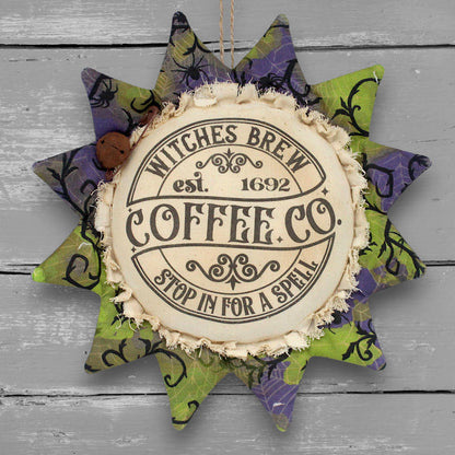 Primitive handmade fabric sunflower ornament for Halloween with a printed center that reads "Witches Brew Coffee Co. stop in for a spell."