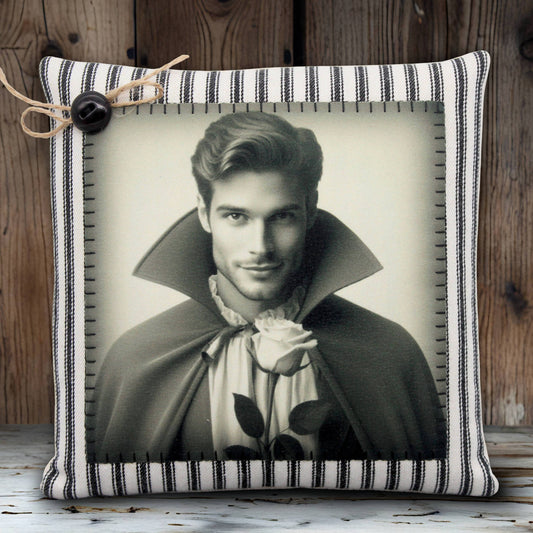 Decorative pillow with a black and white portrait of a handsome young vampire in a cape holding a rose, on a striped background.