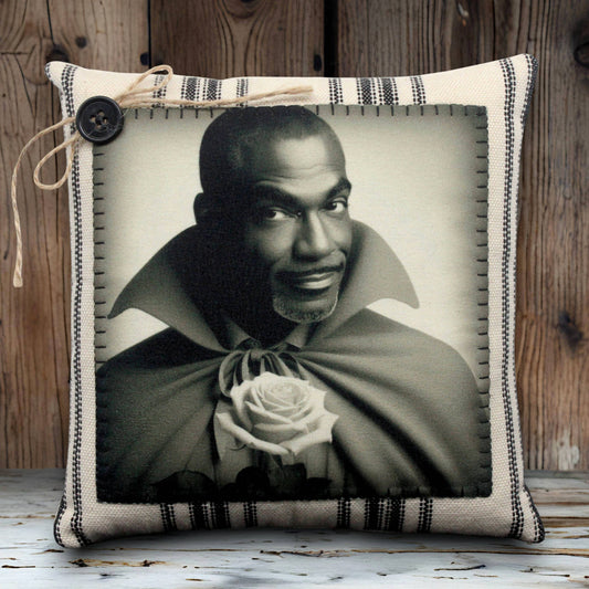 Pillow with a black and white portrait of a handsome vampire holding a rose, framed by decorative fabric.