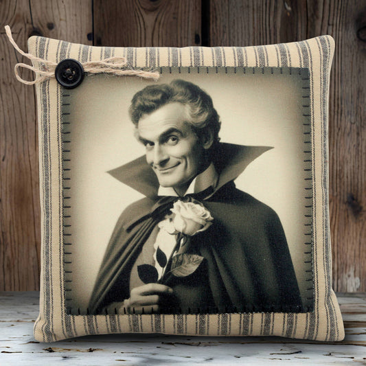 Decorative pillow with a vintage-style portrait of a handsome vampire in dark cape holding a rose, framed by striped fabric.