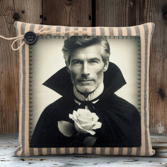 Decorative pillow with a black and white portrait of a handsome vampire holding a rose, framed by striped fabric.