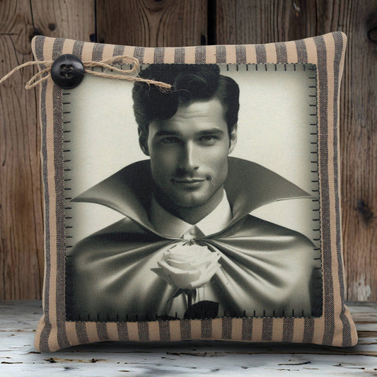 Decorative pillow with a black and white portrait of a young vampire in a cape holding a rose, framed by striped fabric.