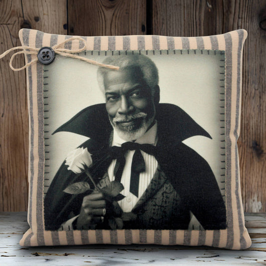 Decorative pillow with a black and white portrait of a handsome vampire holding a flower, framed by striped fabric.