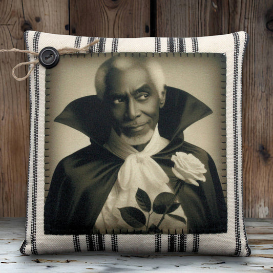 Pillow with a vintage-style print of a handsome vampire in a dark robe holding a white rose on a striped background.