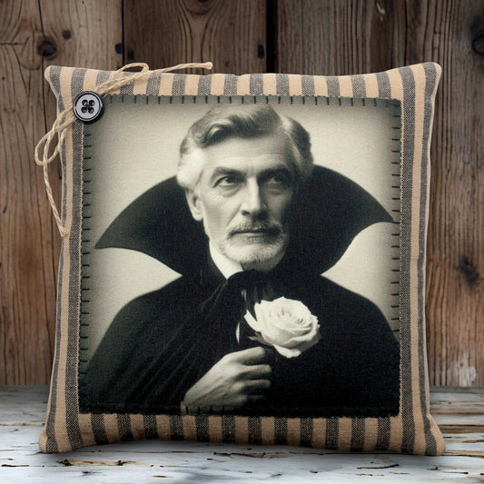 Pillow with a vintage-style portrait of a vampire in a dark robe holding a white rose, framed by striped fabric.