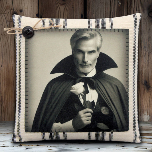 Decorative pillow with a portrait of a handsome vampire in a cape holding a rose, framed by striped fabric.