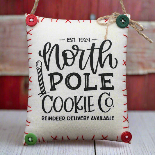 Hanging mini pillow sign ornament with 'North Pole Cookie Co.' text