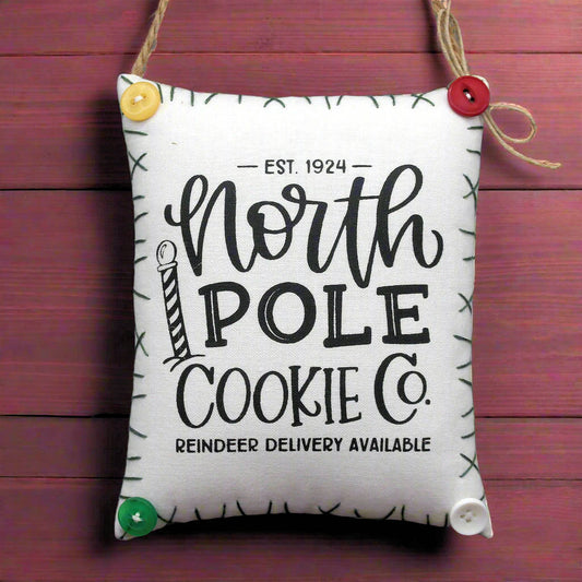 Fabric bag with 'North Pole Cookie Co.' text on a wooden background