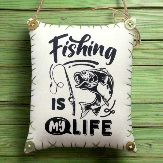 Decorative pillow with 'Fishing is my life' text and fish illustration on a wooden background