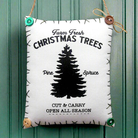 Decorative sign with Christmas tree design and text on a green wooden background