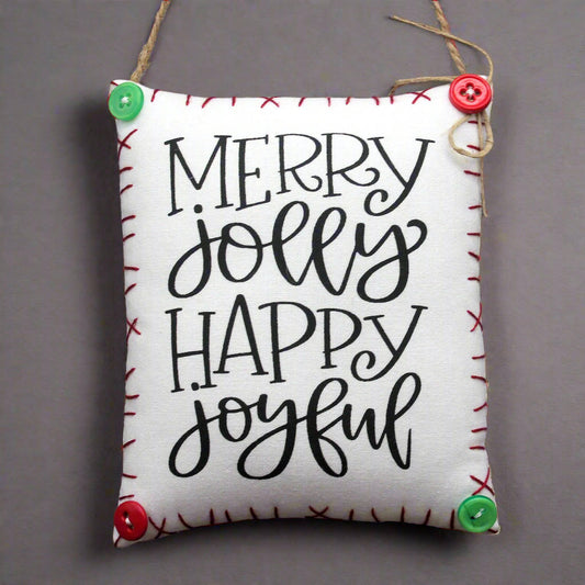 Decorative sign with 'Merry Jolly Happy Joyful' text on a plain background