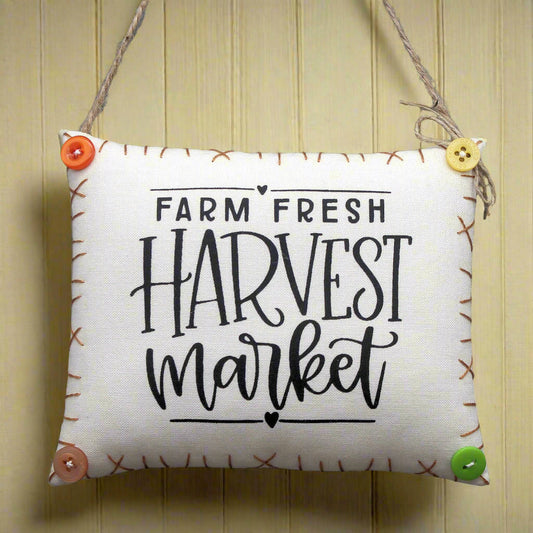 Decorative sign with 'Farm Fresh Harvest Market' text on a wooden background