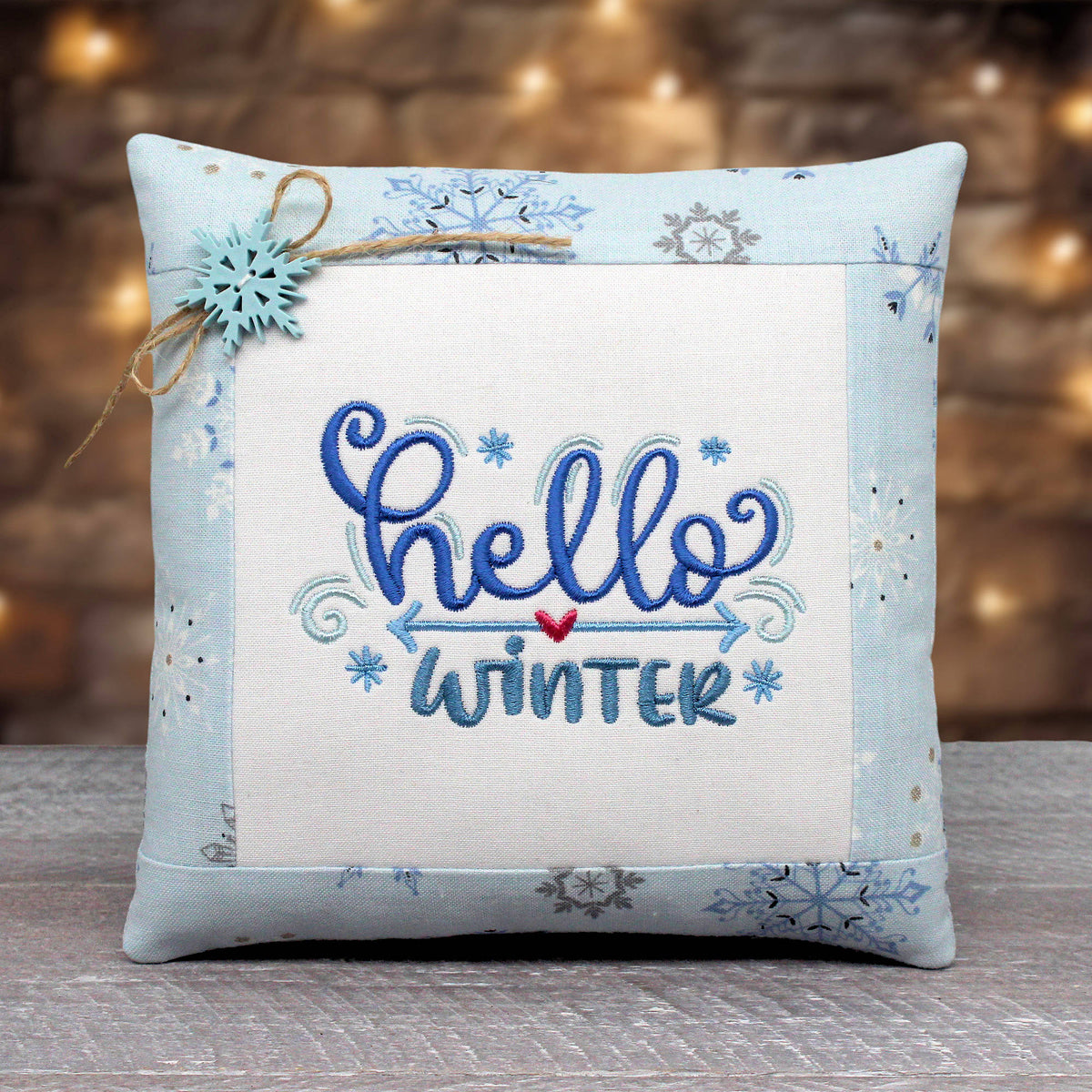 Small pillow tuck or bowl filler embroidered with 'hello winter' and done up in soft icy blue colors and fabric trim.