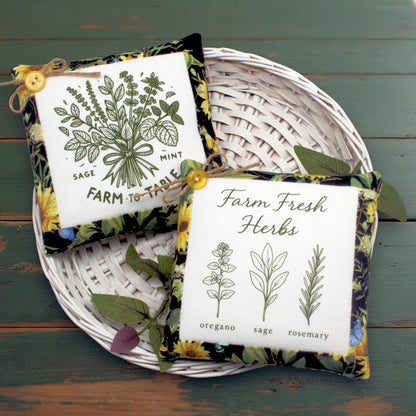 Set of two fabric mini pillow bowl fillers with herb garden-themed designs, displayed in a white basket on a wooden table