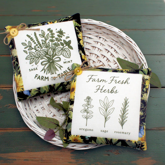 Set of two fabric mini pillow bowl fillers with herb garden-themed designs, displayed in a white basket on a wooden table