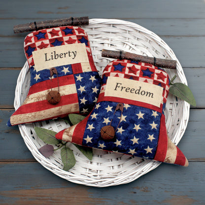 Set of two primitive fabric Liberty Bells sewn from Americana print fabrics.  They have rusty bells and safety pins 