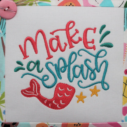 A square decorative throw pillow with a white center panel embroidered with the phrase 'make a splash' in coral and teal lettering, plus a mermaid tail and yellow starfish. The pillow has a colorful beach-themed border.