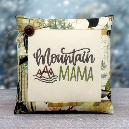 Small pillow tuck or bowl filler embroidered with 'mountain mama' and trimmed with a fabric with a rustic woodsy design