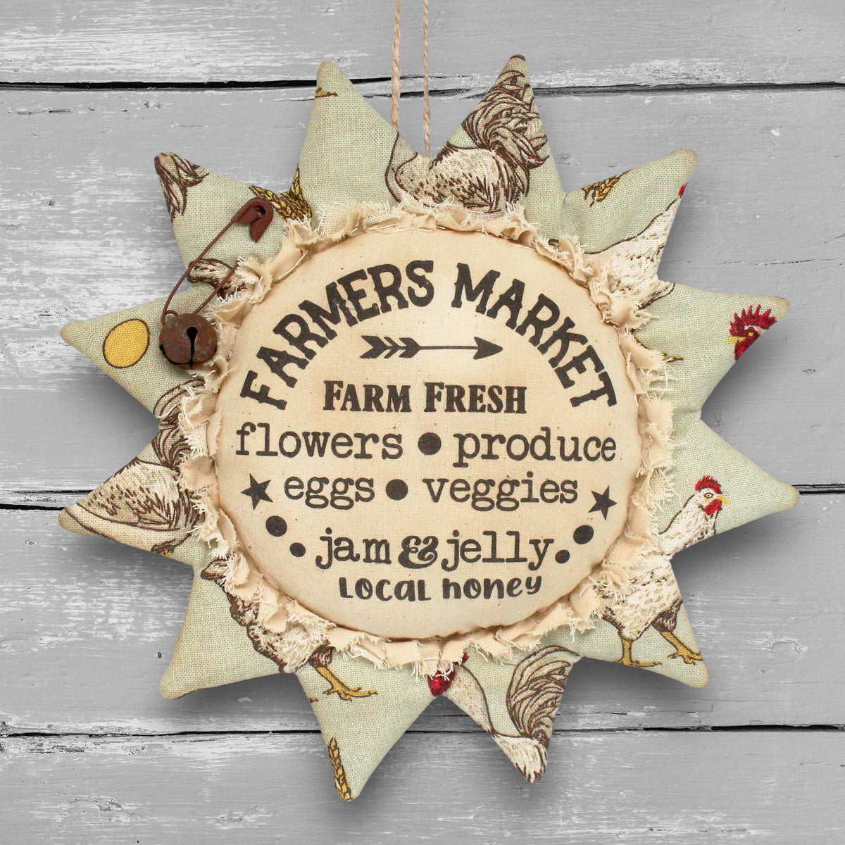 Primitive distressed handmade fabric sunflower ornament with a printed center that advertises for a local farmers market.