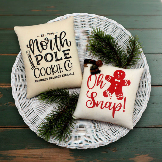 Set of two screen-printed mini pillow bowl fillers with gingerbread cookie text and designs