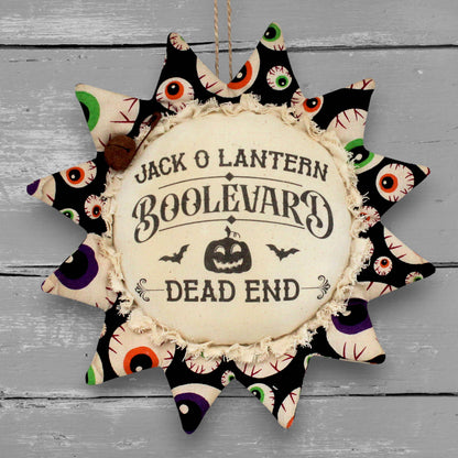 Handmade primitive sunflower ornament with a printed center that reads "Jack O Lantern Boolevard - Dead End"