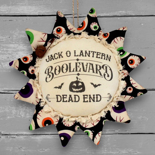 Handmade primitive sunflower ornament with a printed center that reads "Jack O Lantern Boolevard - Dead End"