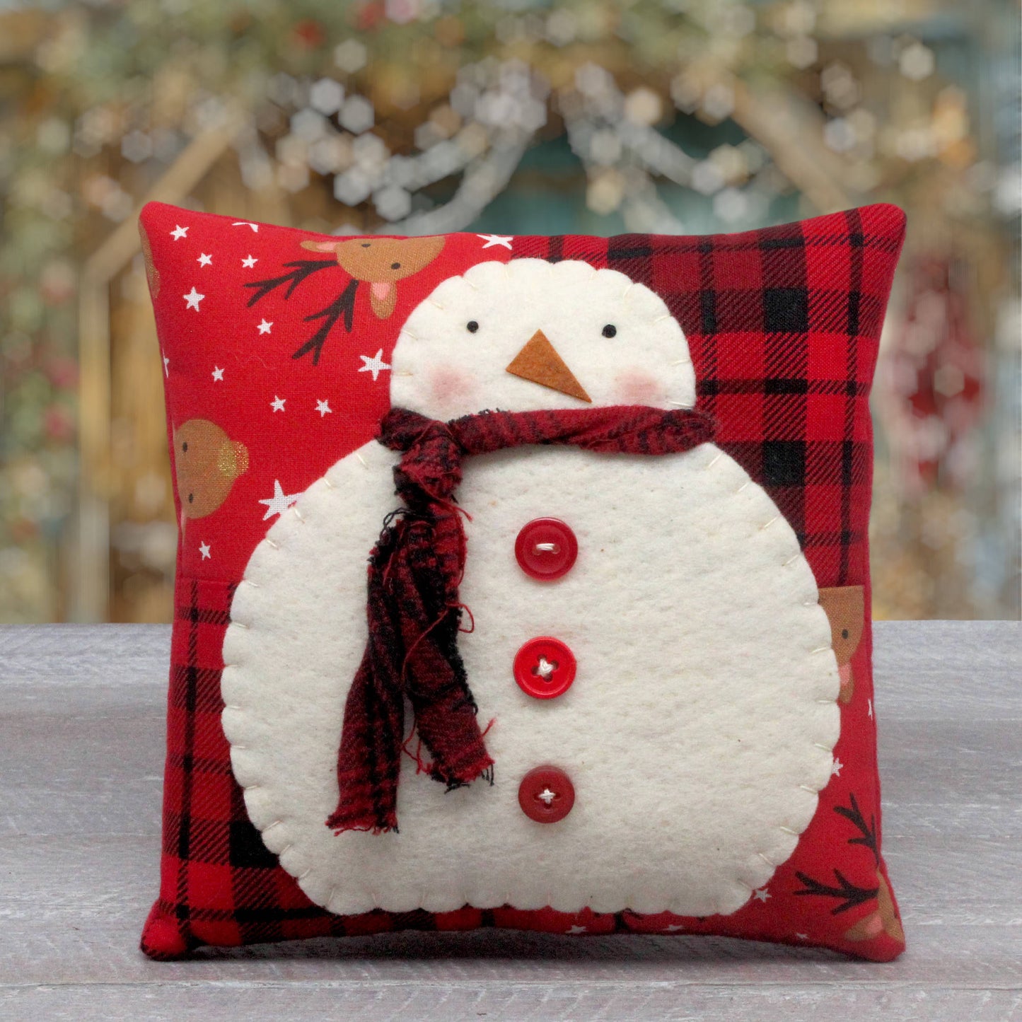 Decorative country primitive snowman pillow has a 4-patch pieced background.