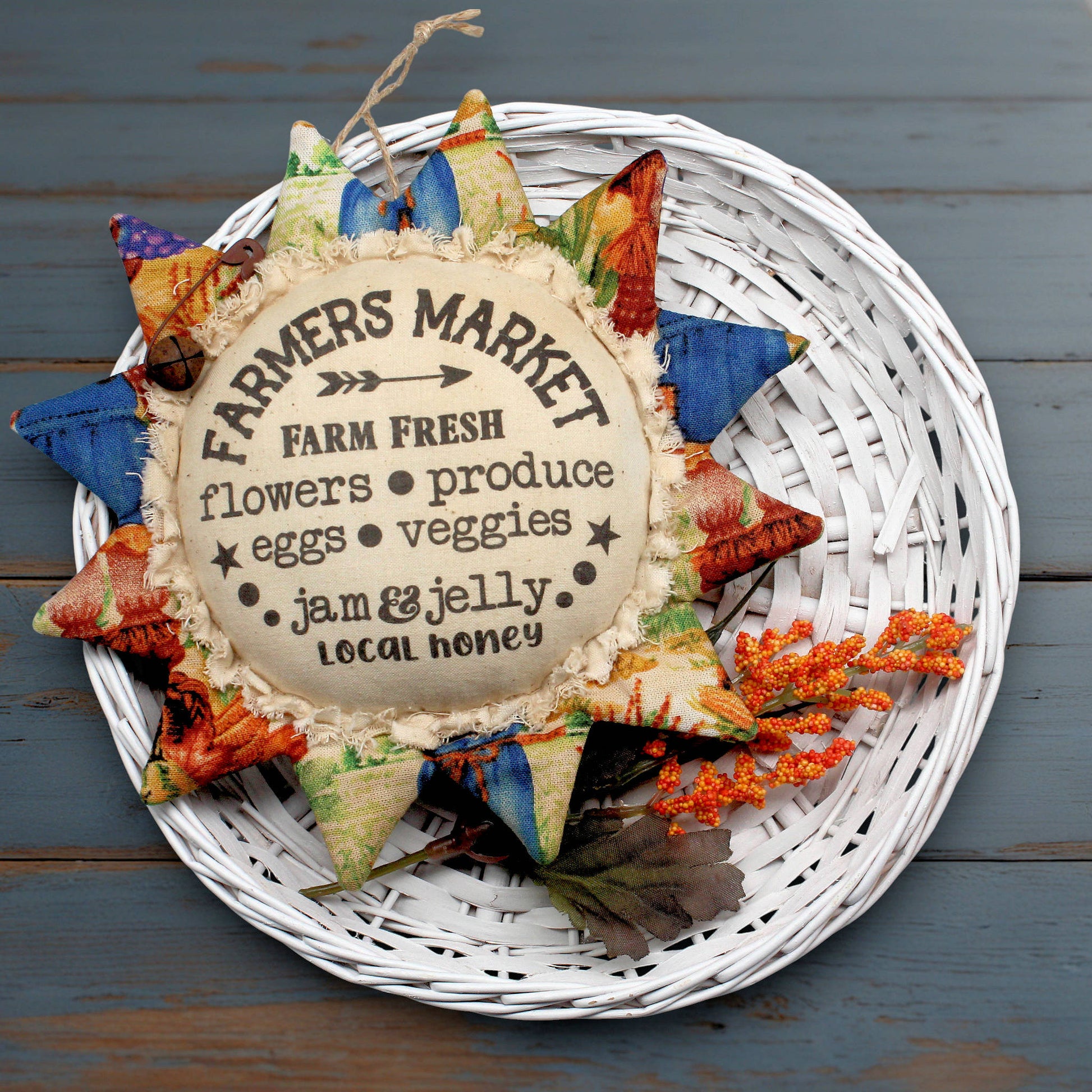 Primitive fabric sunflower ornament with an advertisement for a farmers market