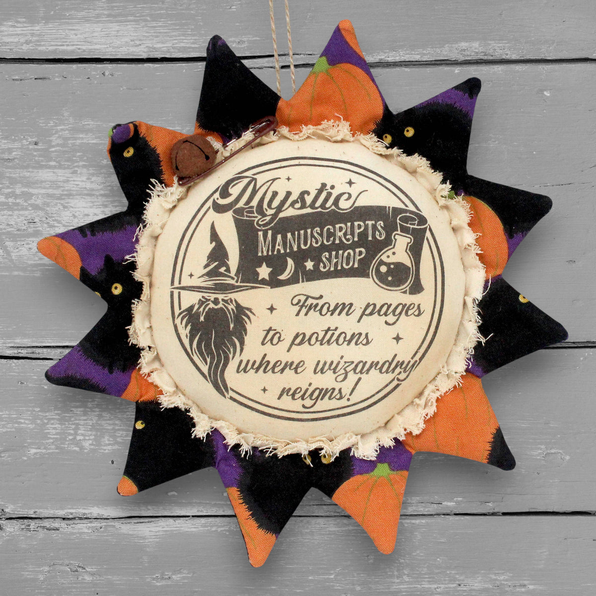 Handmade primitive fabric sunflower ornament with a printed center that advertises for a wizard's manuscript shop.