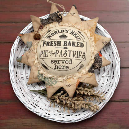 Primitive sunflower ornament with an advertisement for pies and pastries