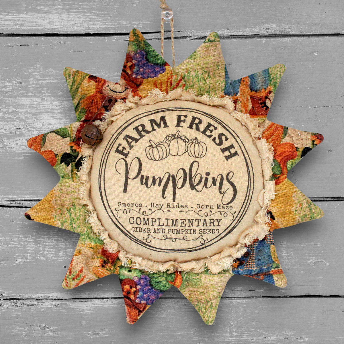 Handmade primitive fabric sunflower ornament with a printed center that advertises for farm fresh pumpkins