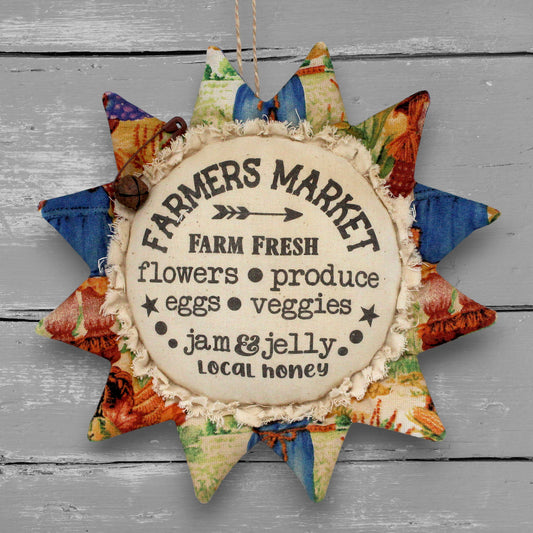 Primitive handmade fabric sunflower ornament with a printed center that advertises for a farmers market