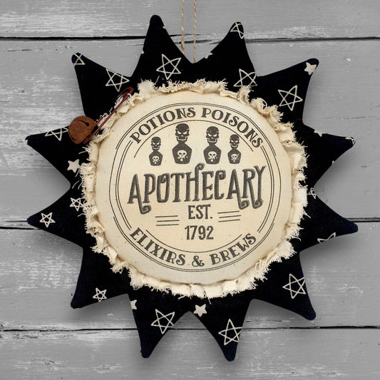 Primitive handmade fabric sunflower ornament with a printed center that advertises for a Halloween apothecary with brews, elixirs and potions.