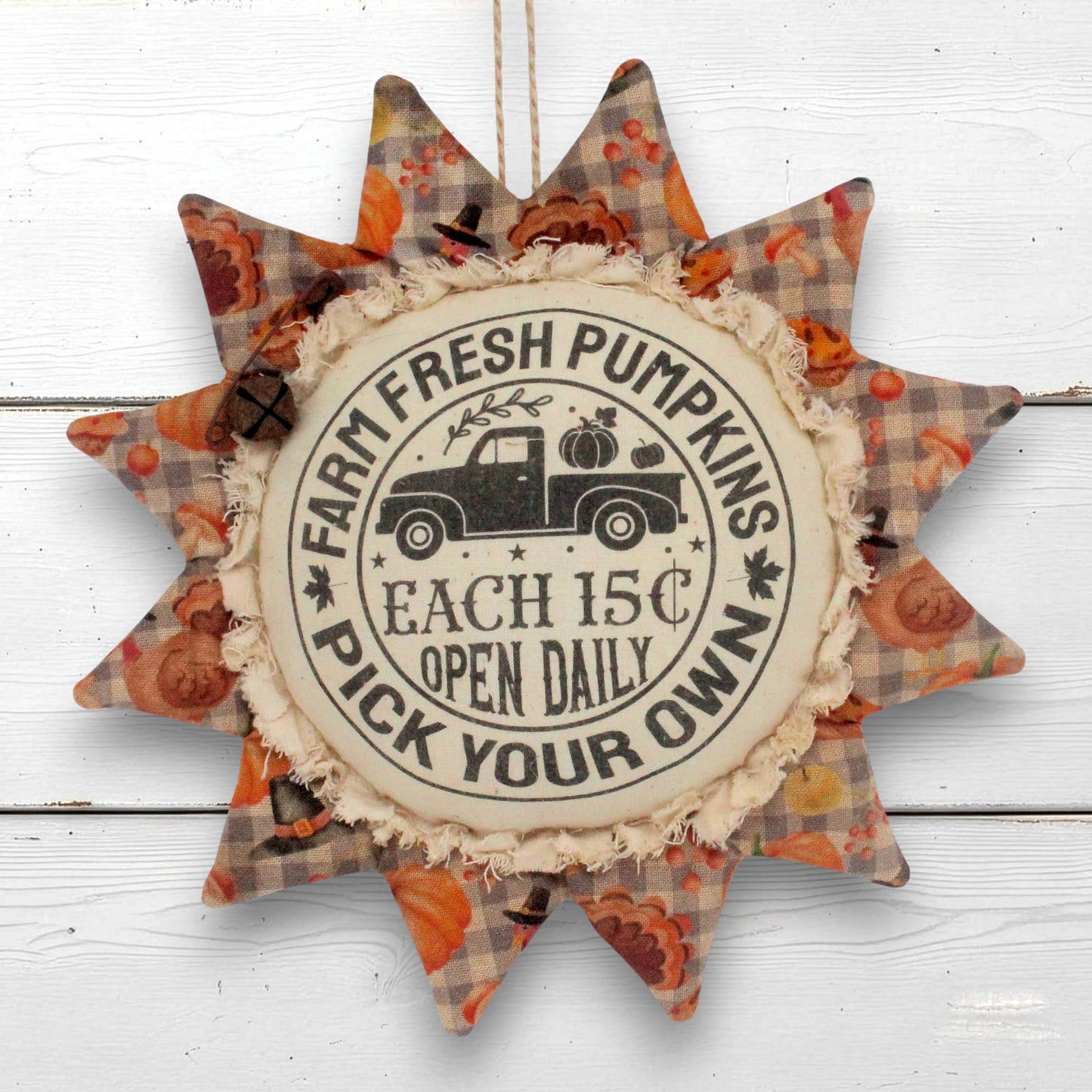 A sunflower ornament autumn hanging ornament with a central circular sign reading 'Farm Fresh Pumpkins Each 15c Open Daily Pick Your Own' and a vintage truck illustration, surrounded by patterned star points in orange, brown, and beige plaid.