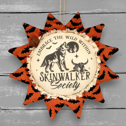 Primitive handmade Halloween sunflower ornament with a printed center that advertises for the Skinwalker Society.