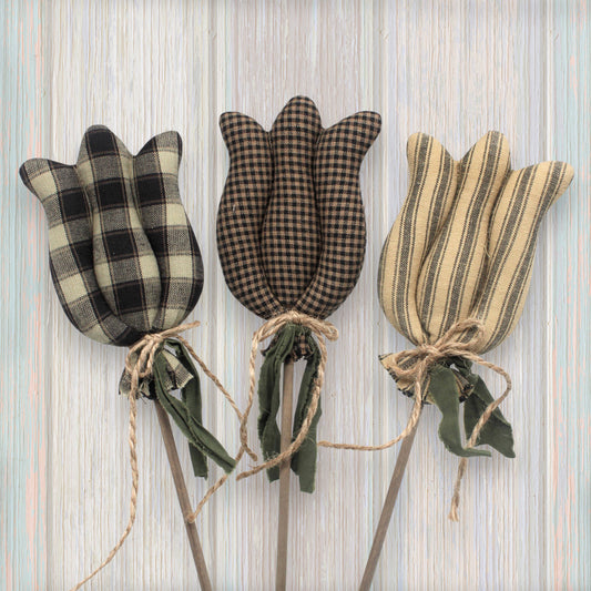 Three fabric tulips in plaid and striped patterns on a textured background