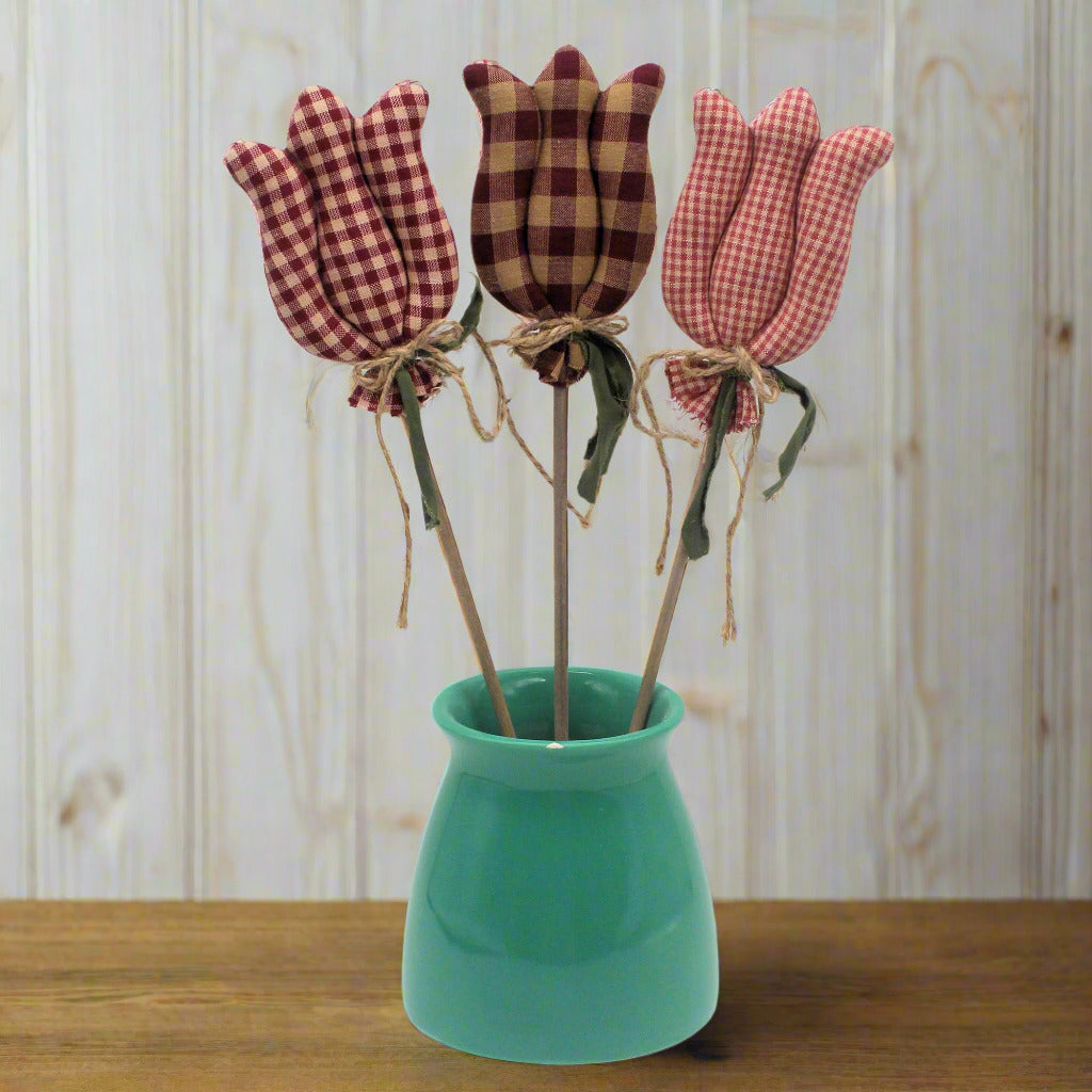 Three fabric tulips in a green vase on a white background